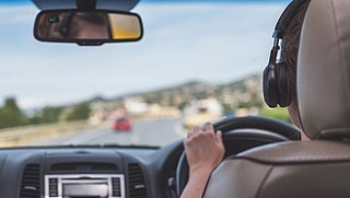 Koptelefoon of oordopjes dragen tijdens het autorijden: mag dat wel?